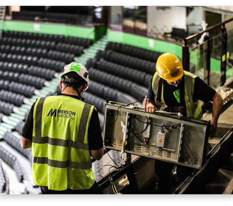 Two workers hold an LED Panel from the LED ticker display at Manchester AO Arena