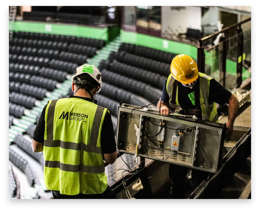Two workers hold an LED Panel from the LED ticker display at Manchester AO Arena